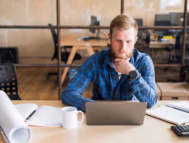 bearded-man-working-laptop-workplace_23-2148187162